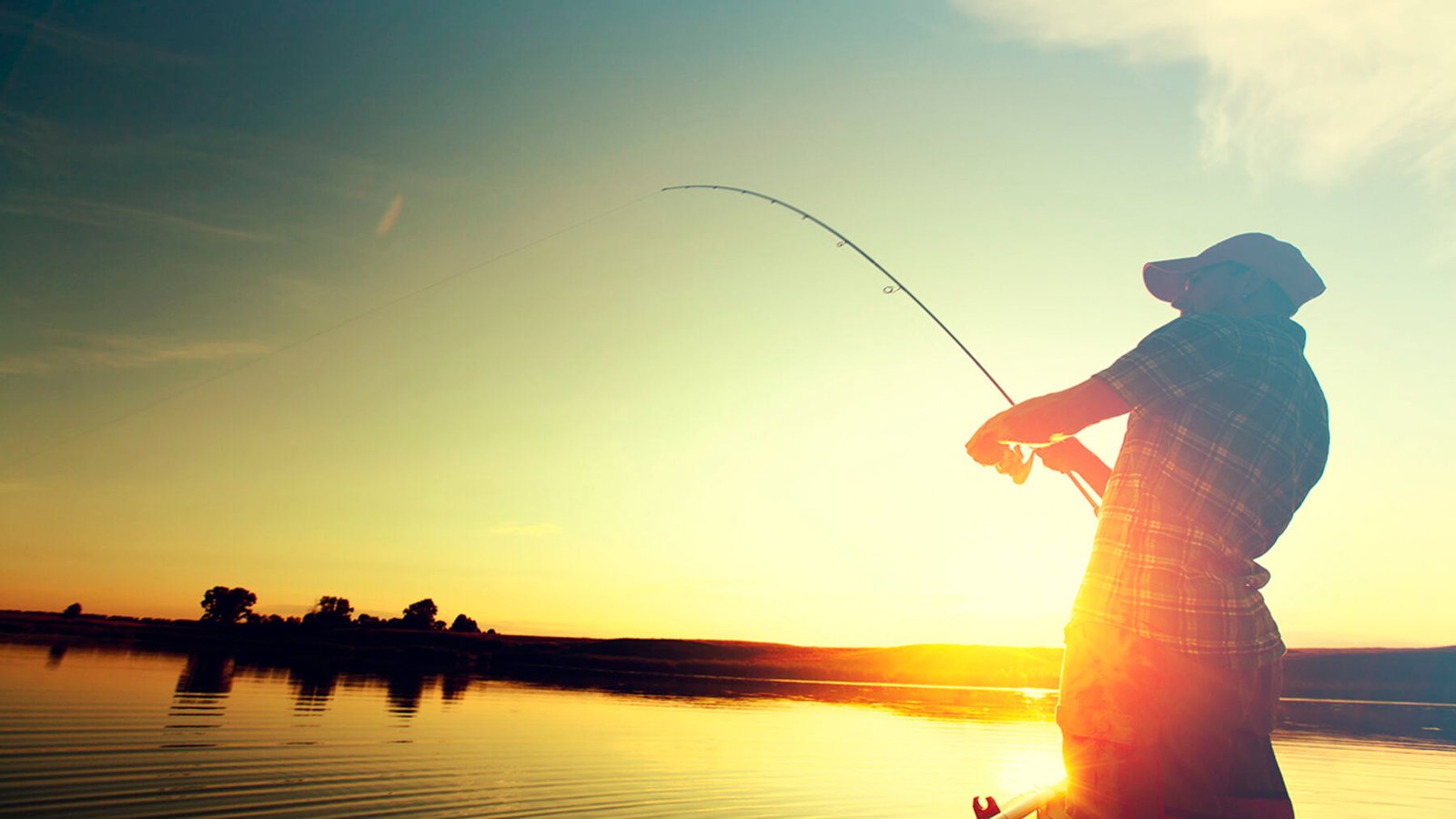 Pescador ao pôr do sol lançando a linha
